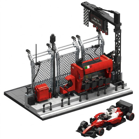 12GO 95026 - trạm xuất phát F1 với pit wall đỏ, hàng rào lưới bạc, cổng đèn và xe đua đỏ trắng đặt riêng bên dưới