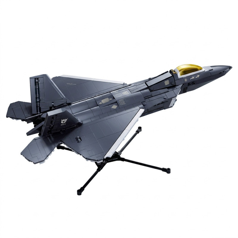 Mô hình Sluban M38-B1613 F-22A-S màu xám đặt trên giá ba chân, nắp buồng lái vàng trong, nhìn chếch từ phía trước bên phải