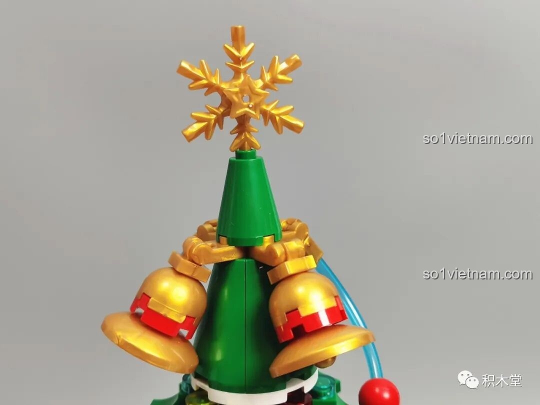 Cận cảnh đỉnh cây thông Noel của bộ JAKI JK5128 với ngôi sao và chuông vàng lấp lánh.