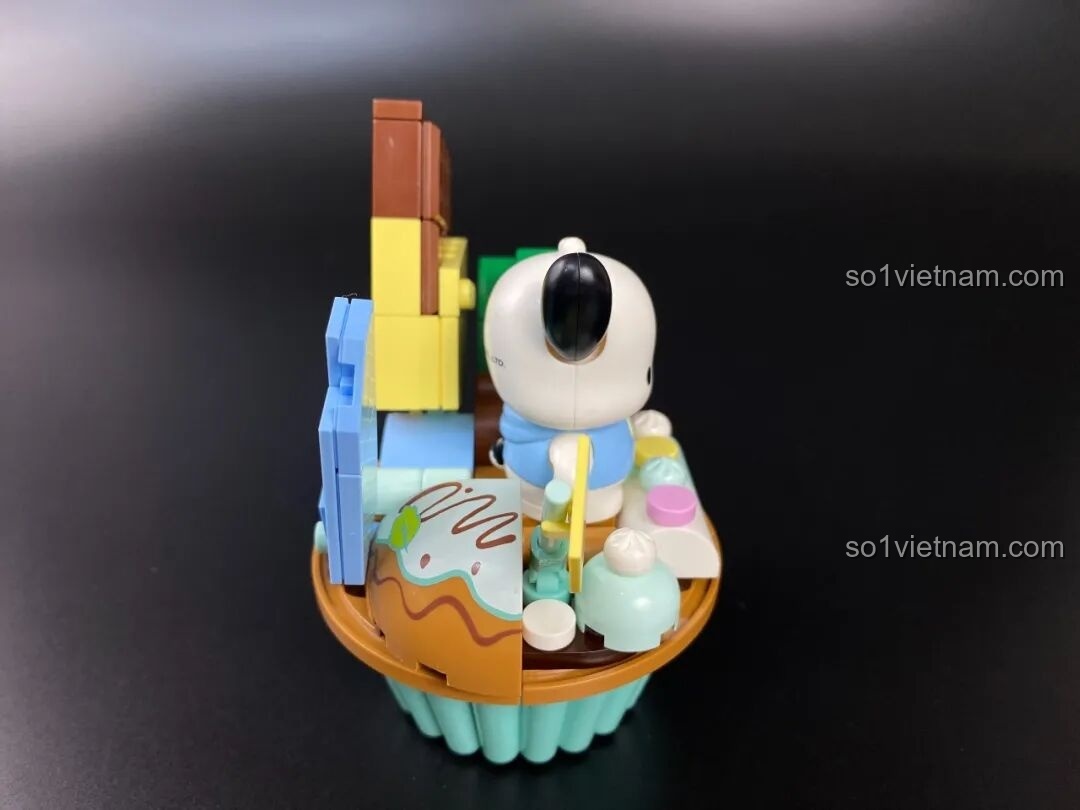 Góc nhìn bên trái của mô hình cupcake Pochacco, cho thấy sự sắp xếp khéo léo của các chi tiết trang trí.