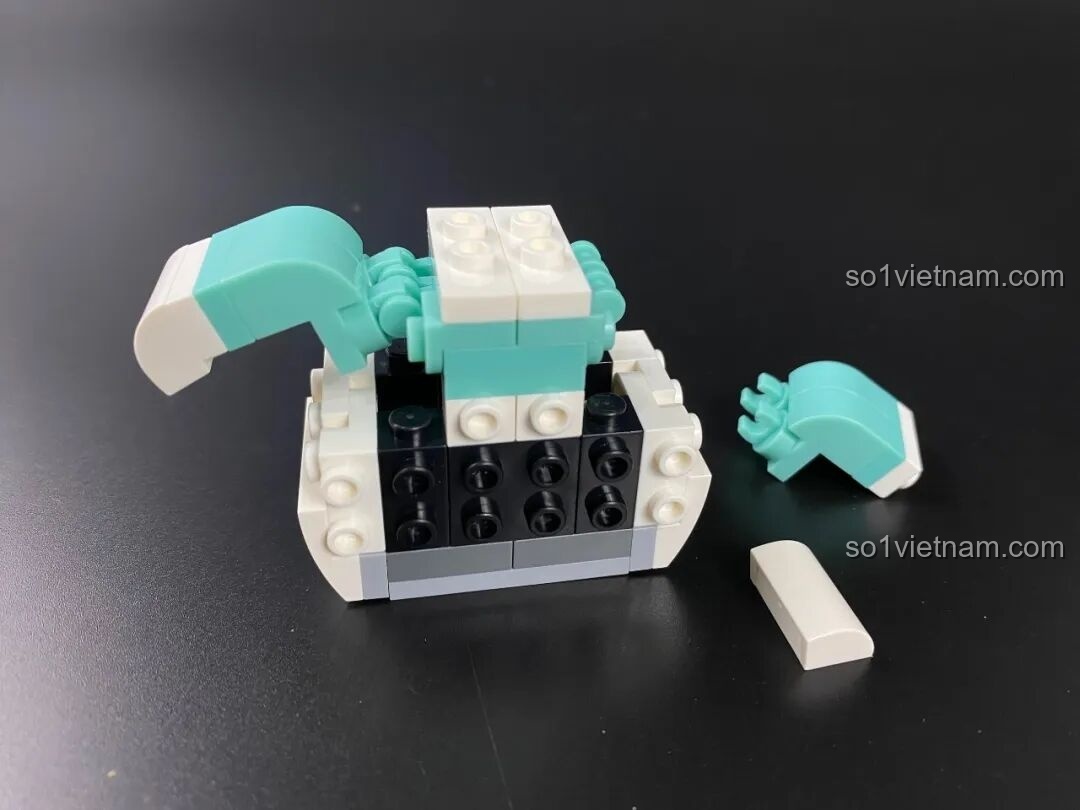 Lắp ráp phần thân của figure Pochacco KUPPY với áo màu xanh mint, một công đoạn đòi hỏi sự khéo léo.