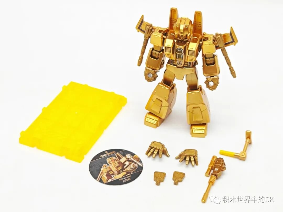 Starscream mạ vàng đứng cạnh phụ kiện tay thay thế