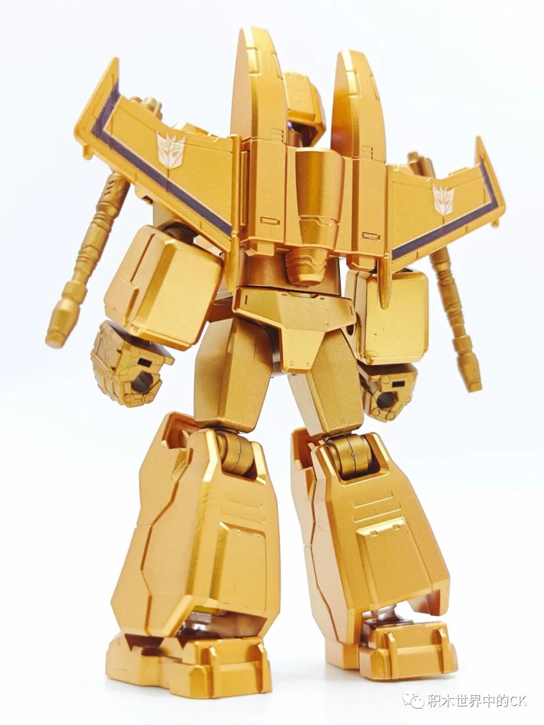 Starscream mạ vàng nhìn chính diện với hai cánh xếp lớp
